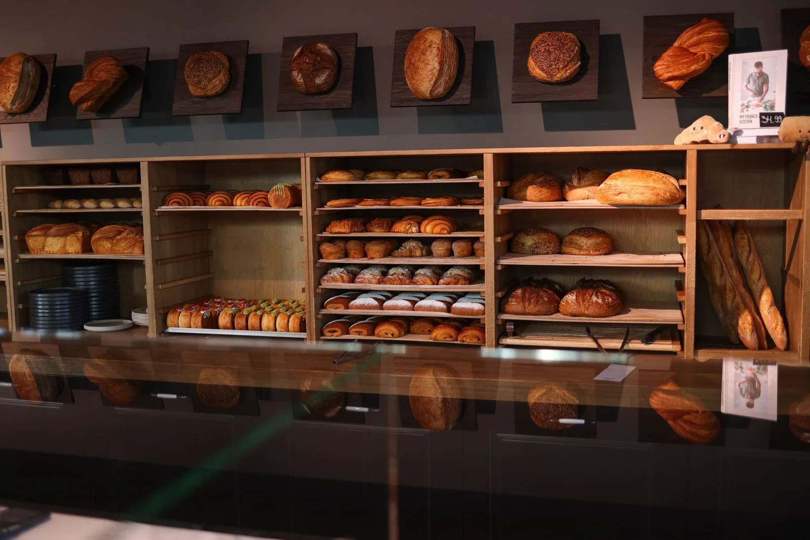 Una acogedora panadería que exhibe una variedad de pan y pasteles recién horneados en estantes de madera.